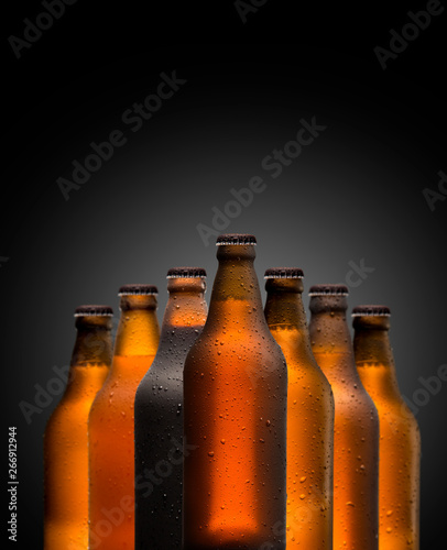 Branding and marketing concept for beer with a line of unopened unlabelled full blank brown bottles on a dark shadowy background conceptual of Oktoberfest or nightlife photo