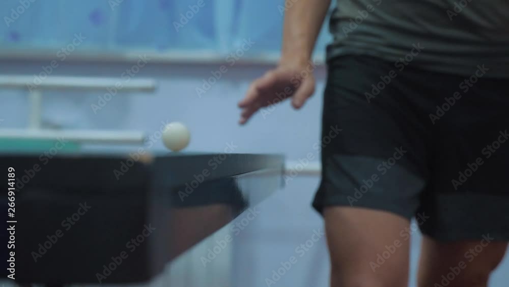 table tennis serve concept. slow motion video. blurred focus on the grid. man playing training serve ball in lifestyle table tennis the sport active
