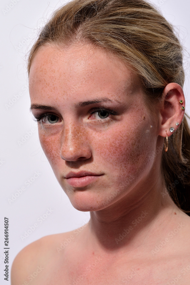 portrait of a young beautiful girl with blue eyes and freckles on a white background portrait of a young beautiful girl with blue eyes and freckles on a white background
