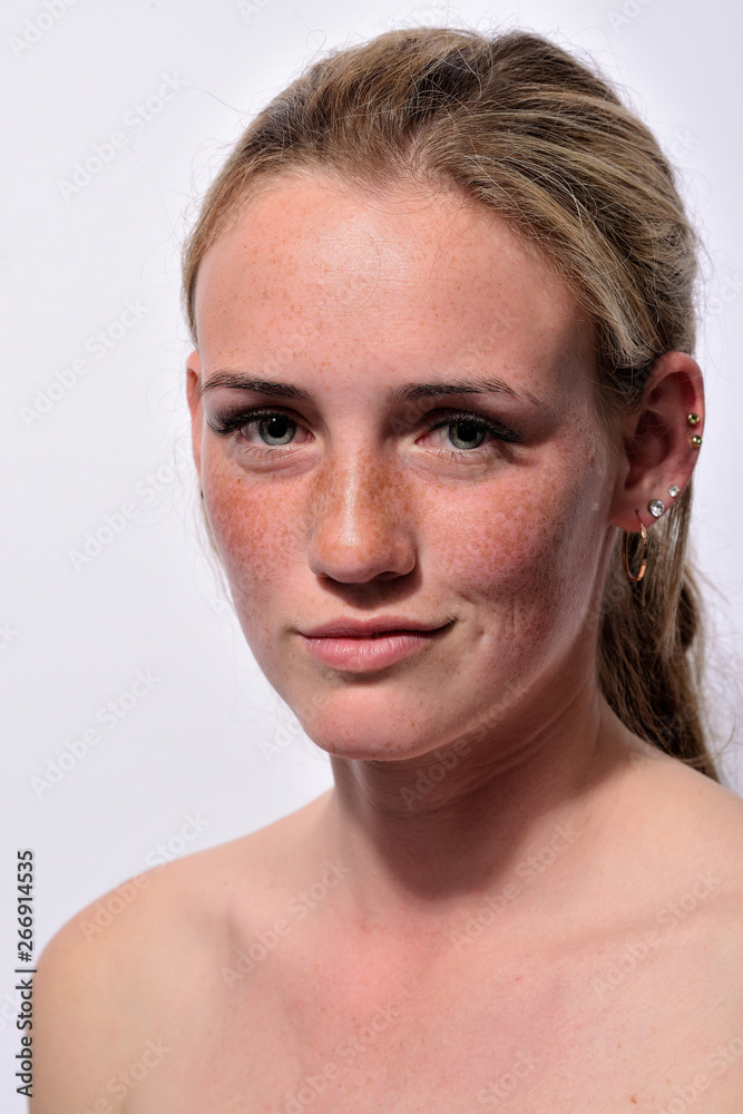 portrait of a young beautiful girl with blue eyes and freckles on a white background