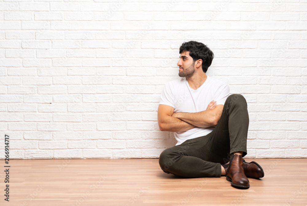 Young man sitting on the floor in lateral position Young man sitting on the floor in lateral position