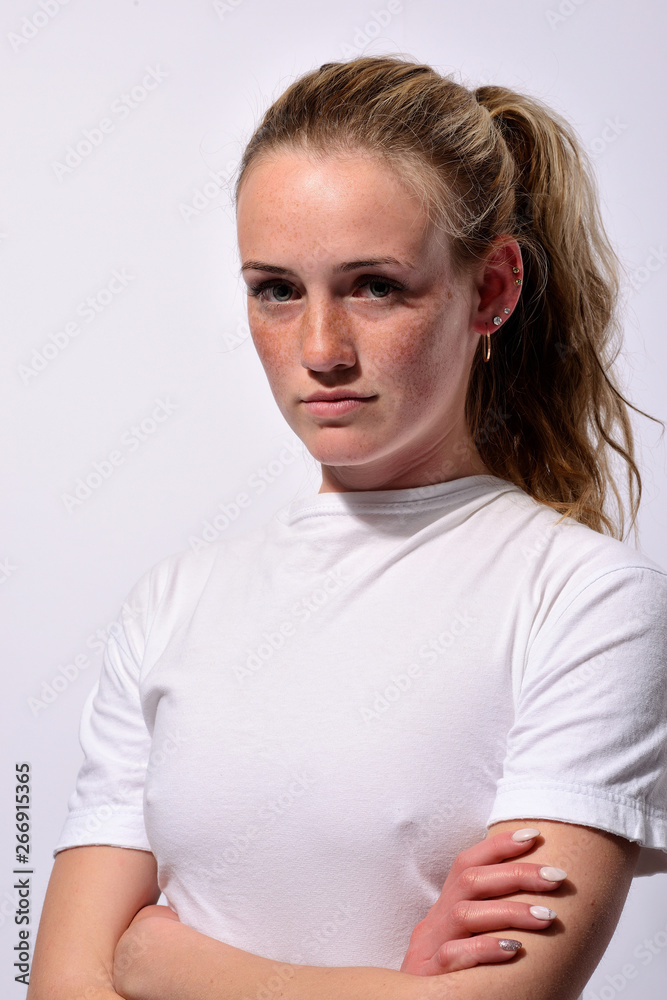 Fototapeta premium portrait of a young beautiful girl with blue eyes and freckles on a white background