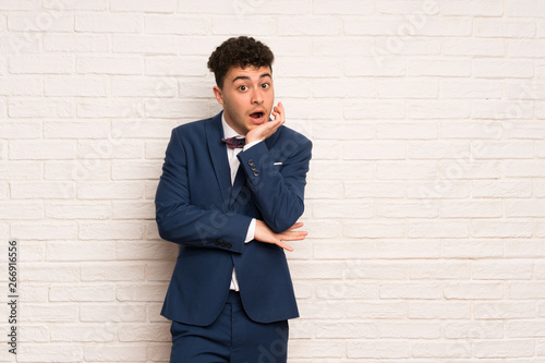 Man in suit and bow tie surprised and shocked while looking right