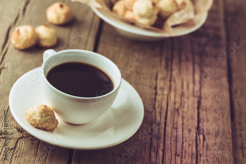 White Cup of Coffee and Homemade Coconut Cookies on Old Wooden Background Horizontal Copy Space Tasty Coconut Dessert and Hot Drink Homemade Coconut Cookies Rustic Morning Breakfast