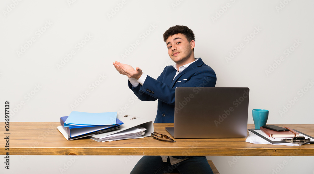 Business man in a office holding copyspace imaginary on the palm to insert an ad Business man in a office holding copyspace imaginary on the palm to insert an ad