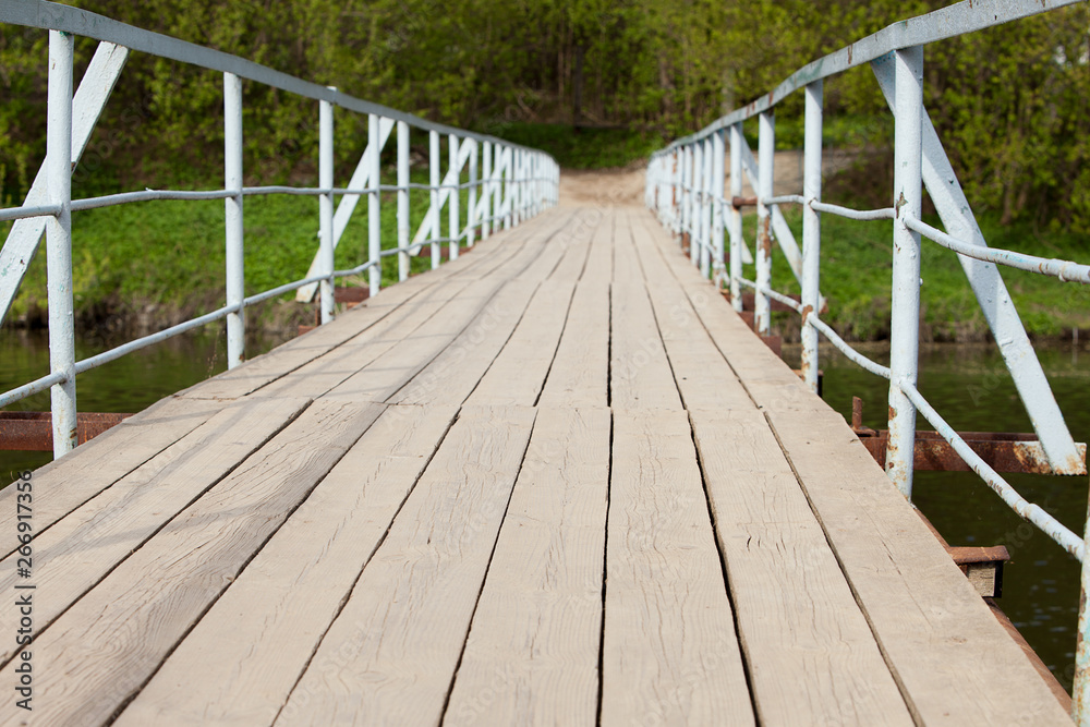 Bridge with blue railings across the Creek in the summer Bridge with blue railings across the Creek in the summer