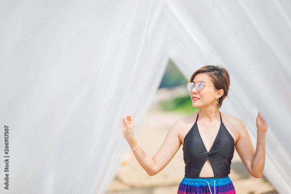 Woman enjoying beach relaxing joyful in summer by tropical sea beach