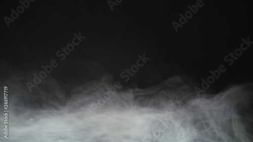 Smoke background. Abstract smoke cloud. Smoke in slow motion on black background. White smoke slowly floating through space against black background. Smoke effect. Fog effect. Smoke machine photo