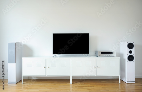 Modern audio stereo system with white speakers on bureau in modern interior © lial88