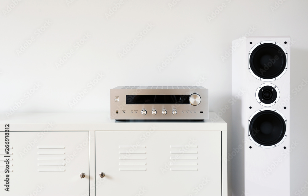 Obraz premium Modern audio stereo system with white speakers on bureau in modern interior