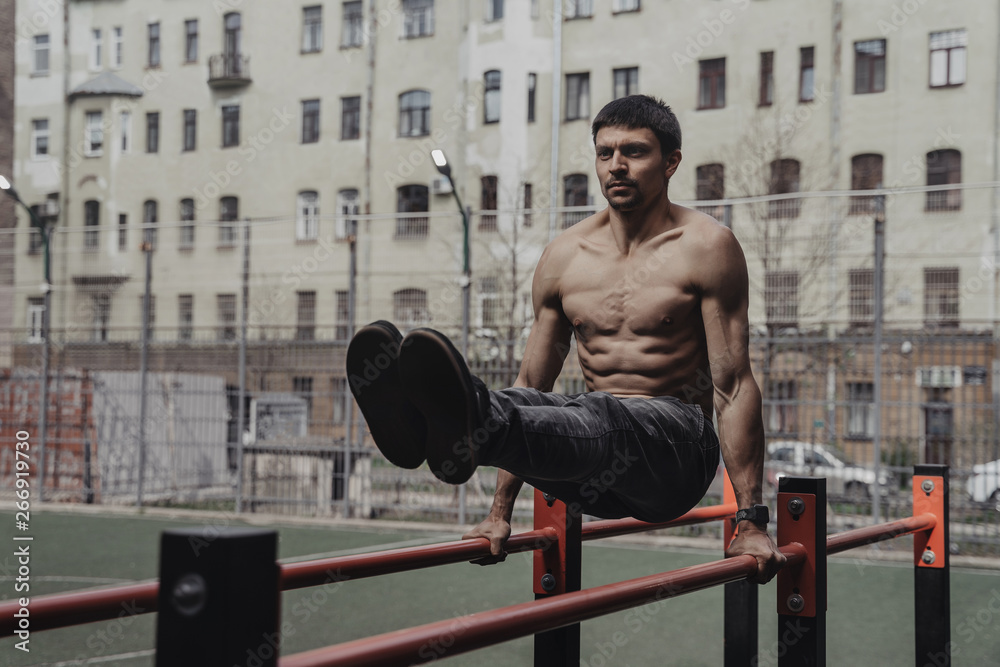 Obraz premium Athlete practicing calisthenics with smartwatch on his wrist.