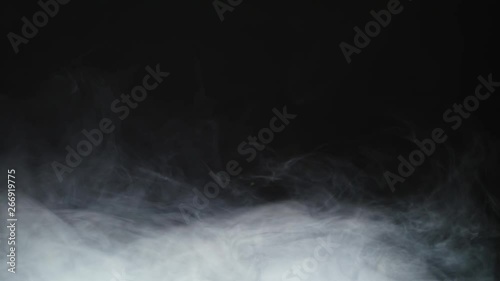 Smoke background. Abstract smoke cloud. Smoke in slow motion on black background. White smoke slowly floating through space against black background. Smoke effect. Fog effect. Smoke machine photo