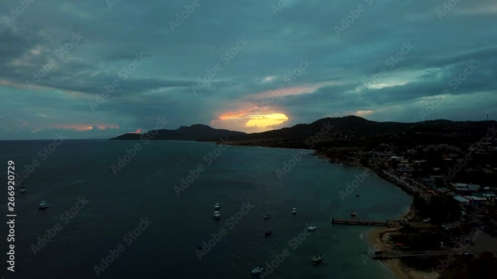 View of the bay of the small town of Esmeralda located in Vieques Puerto Rico during sunset and dusk with beautiful vivid colors among boats, islands, and coast. View of the bay of the small town of Esmeralda located in Vieques Puerto Rico during sunset and dusk with beautiful vivid colors among boats, islands, and coast.