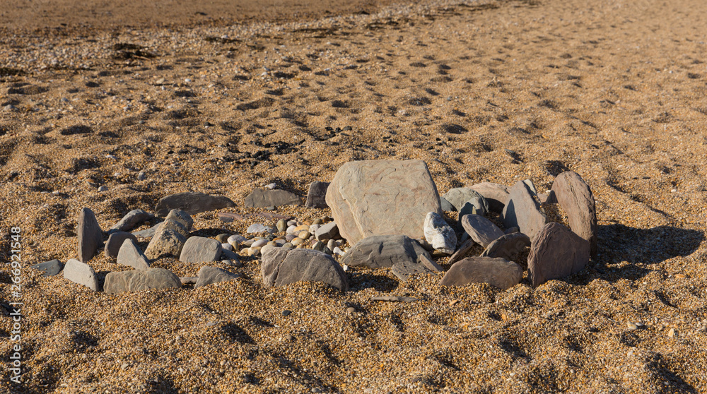 Obraz premium Stones pebbles and slates in a circle on beach 