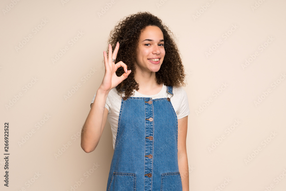 Dominican woman with overalls showing ok sign with fingers Dominican woman with overalls showing ok sign with fingers