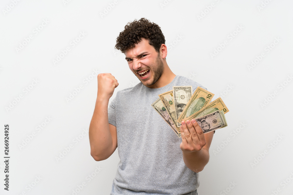 Man with curly hair over isolated wall taking a lot of money Man with curly hair over isolated wall taking a lot of money