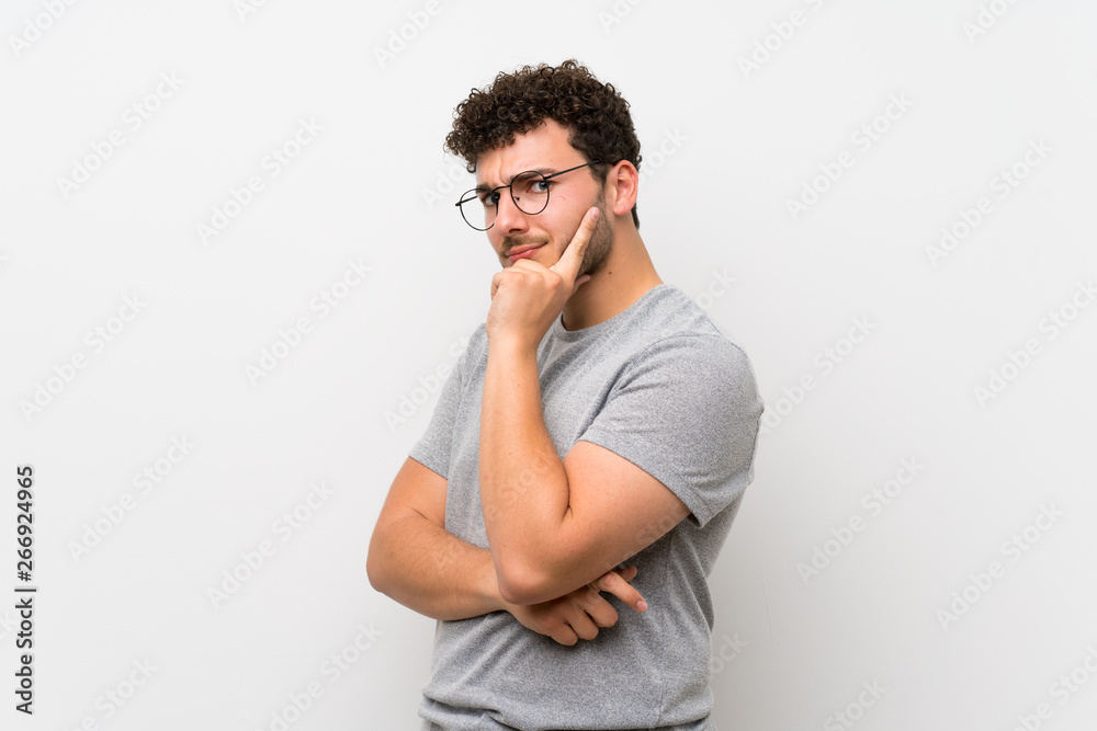 Man with curly hair over isolated wall with glasses Man with curly hair over isolated wall with glasses
