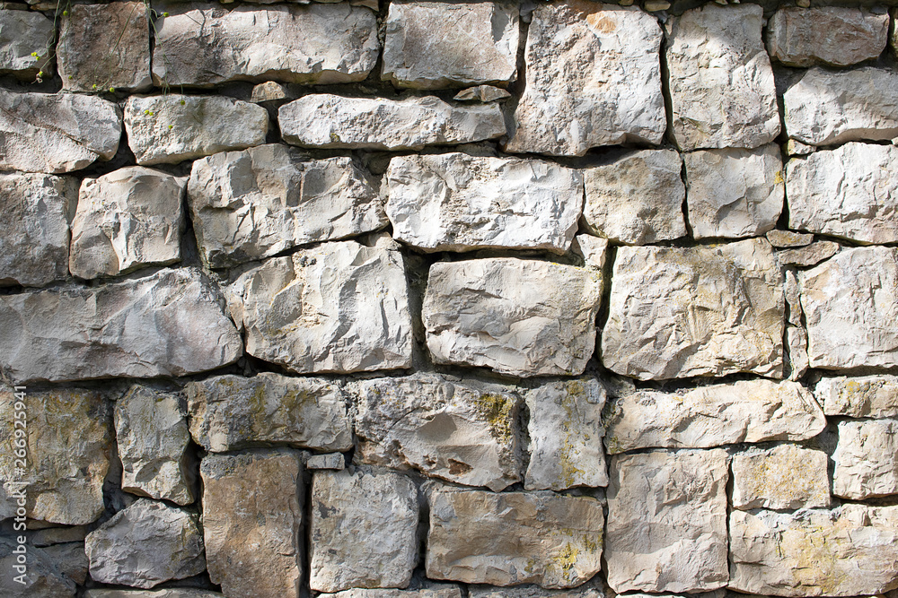 Stone natural wall of different blocks. The texture of the stone lined with blocks of natural stone. Stone natural wall of different blocks. The texture of the stone lined with blocks of natural stone.