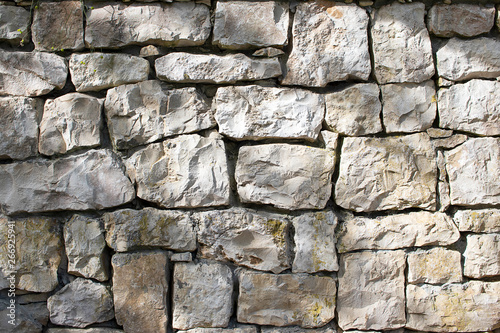 Stone natural wall of different blocks. The texture of the stone lined with blocks of natural stone.