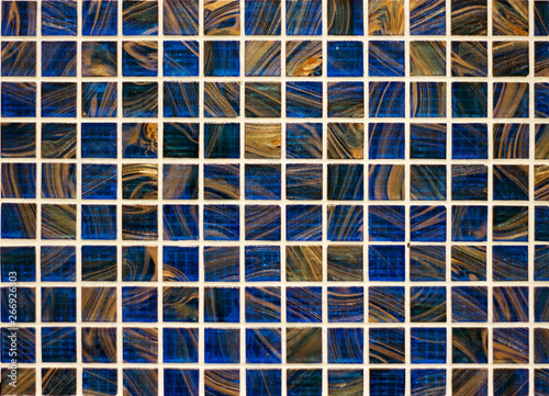 wall of small ceramic tiles texture under natural stone vintage blue and beige