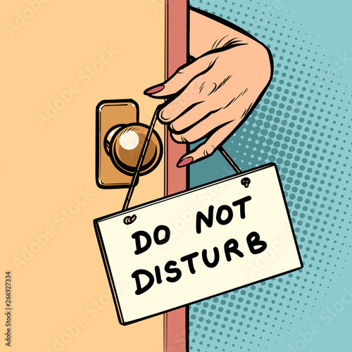 do not disturb woman hand hangs a sign on the door