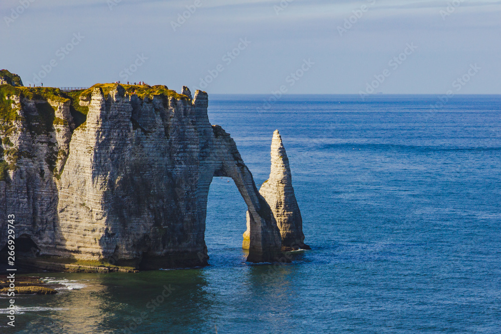 Beautiful famous chalk cliffs Aval of Etretat with tourists and blue water of ocean with gulls, Normandy, France, Europe