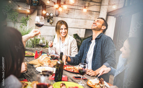 Canvas Print Young friends having fun drinking red wine on balcony at house dinner party - Ha