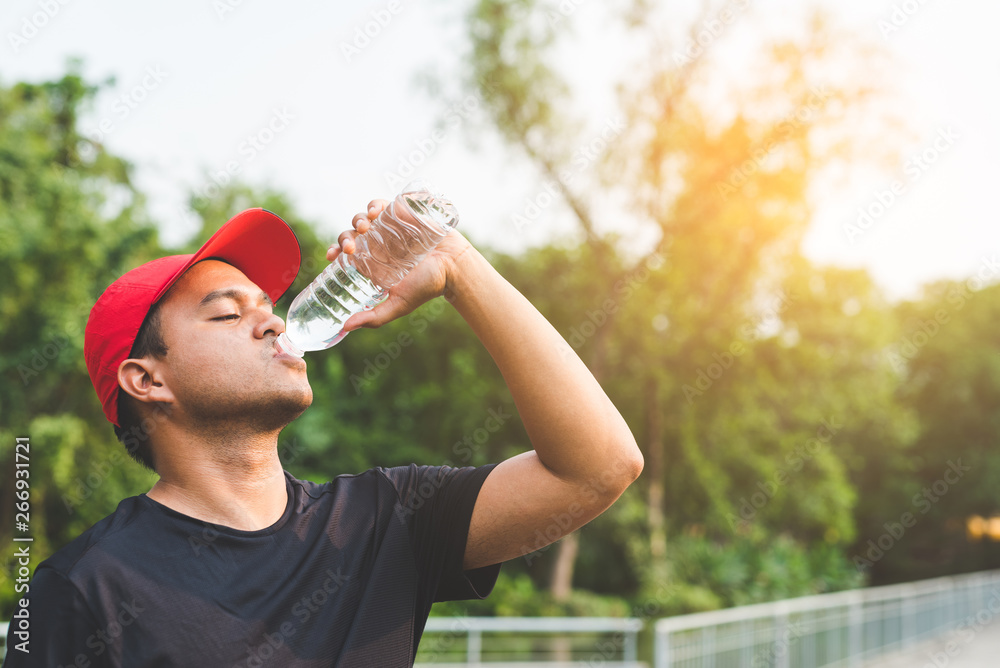 Young fitness man runner drinking bottle of water. Young fitness man runner drinking bottle of water.