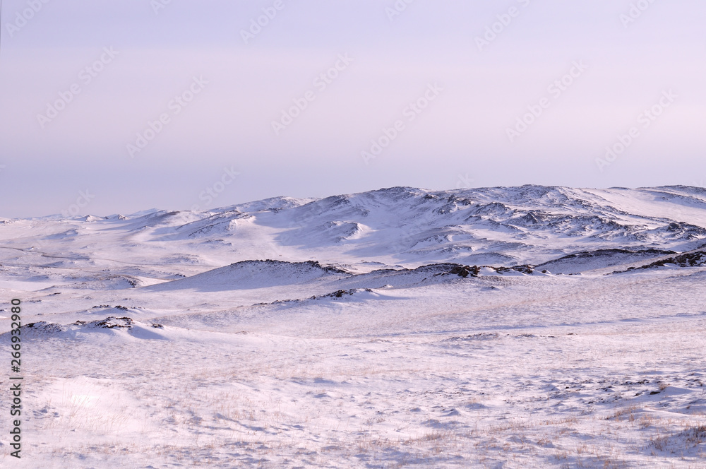 Early morning sunrise in Tazheran steppes. Snow-covered hills are colored in shades of ultra-violet. Photo toned. Early morning sunrise in Tazheran steppes. Snow-covered hills are colored in shades of ultra-violet. Photo toned.