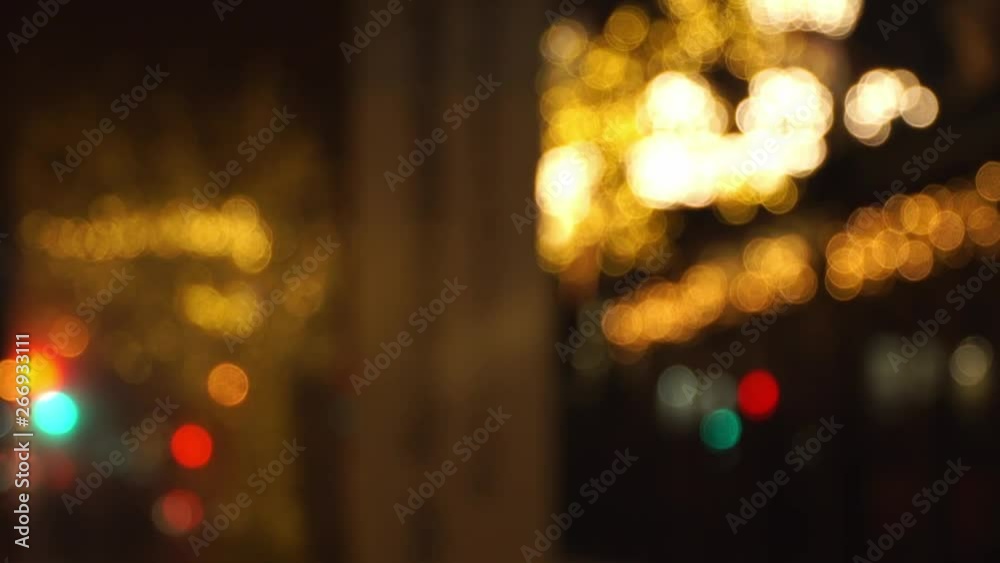 Abstract multicolored bokeh of car headlights and blurred golden bokeh light garland festive decor on evening crossroads of big night city. Christmas and New Year holidays background. Abstract multicolored bokeh of car headlights and blurred golden bokeh light garland festive decor on evening crossroads of big night city. Christmas and New Year holidays background.