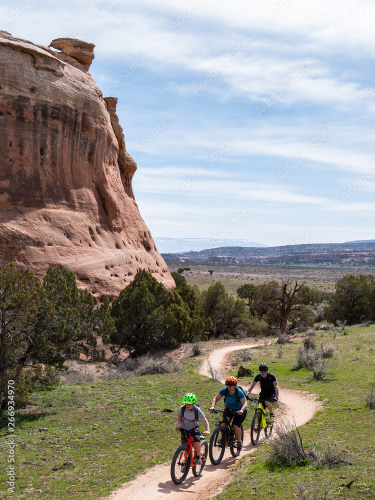 Son, mother and grandfather riding mountain bikes of singletrack in Colorado