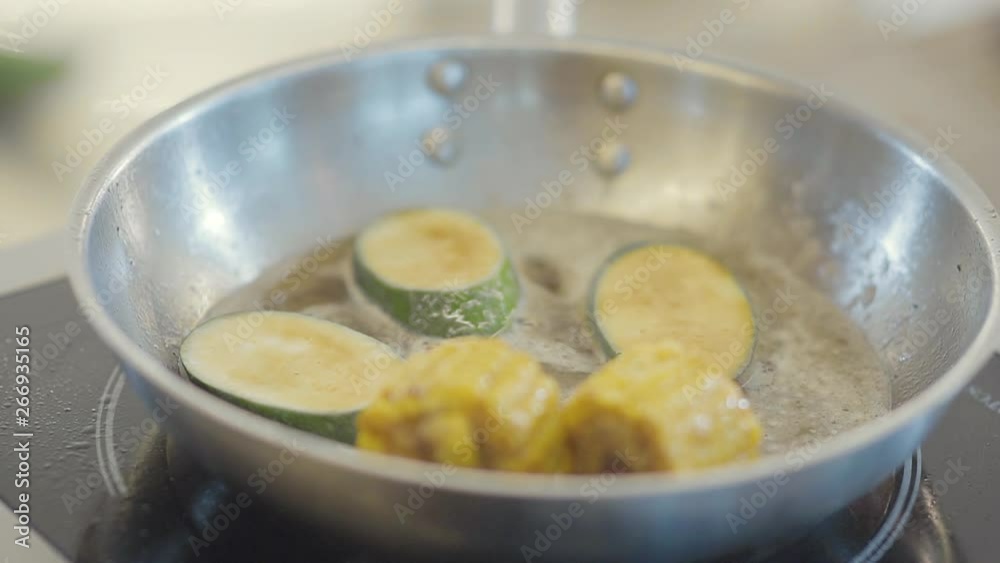 Zucchini and corn in hot frying pan close-up. Zucchini and corn in hot frying pan close-up.