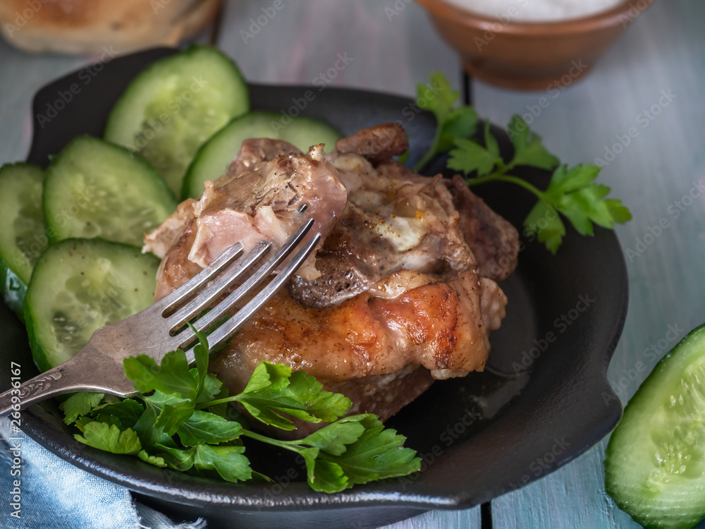 Juicy turkey steak and cucumber slices on a black ceramic plate Juicy turkey steak and cucumber slices on a black ceramic plate