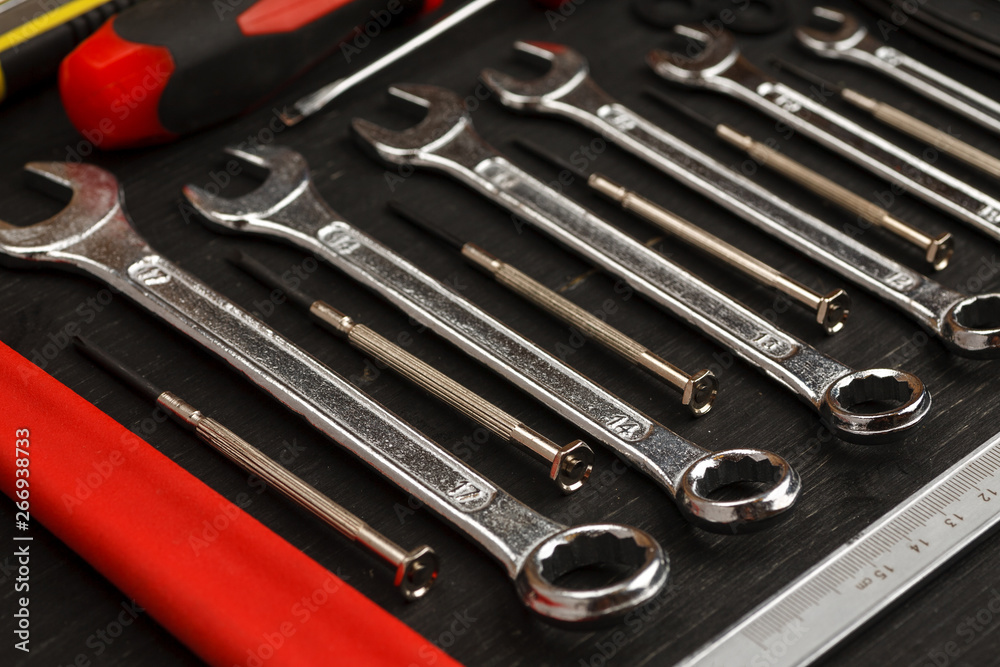 Fototapeta premium Set of different wrenches with other tools on black background