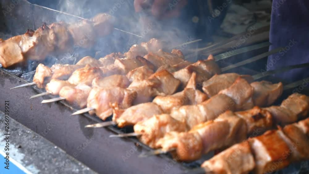 Barbecue on the grill. Сook moves the meat on skewers from side to side. He roasts meat evenly. Сooking meat. Barbecue on the grill. Сook moves the meat on skewers from side to side. He roasts meat evenly. Сooking meat.