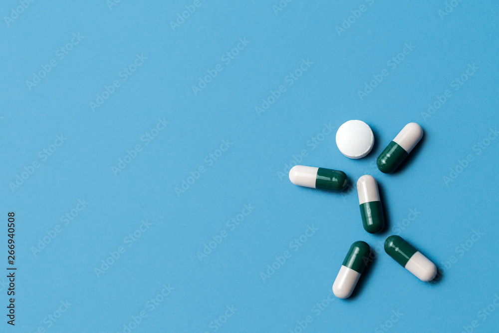 Pills in the shape of a man on blue background. Medical, pharmacy and healthcare concept.