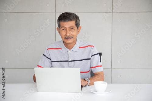 Senior Asia businessman in casual work by use laptop