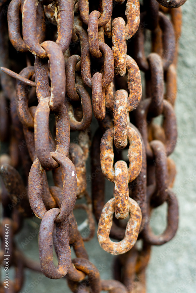 Old rusty metal chain hanging on the wall. Old rusty metal chain hanging on the wall.