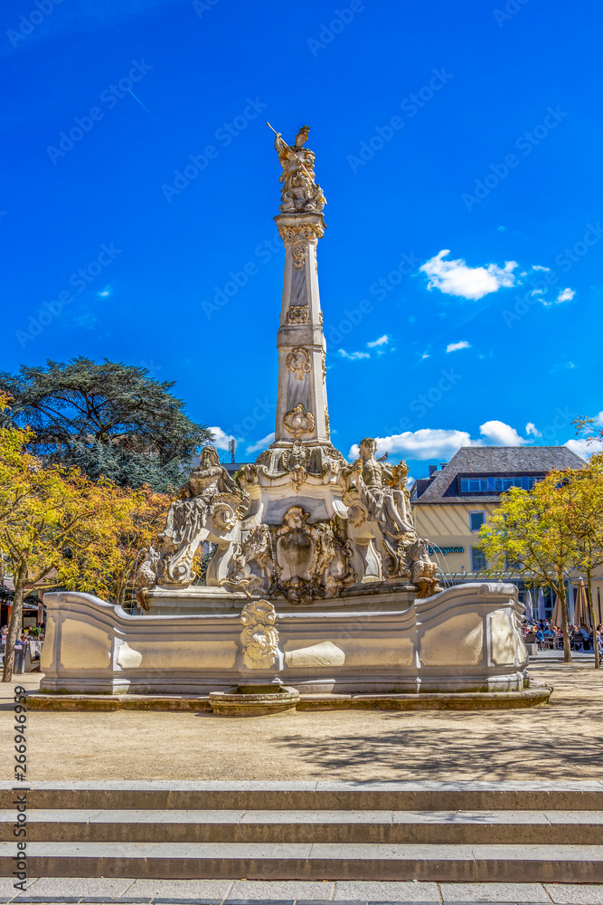 The sunlit Rococo Sankt Georgsbrunnen or St. George's Fountain at the Kornmarkt in Trier, Germany