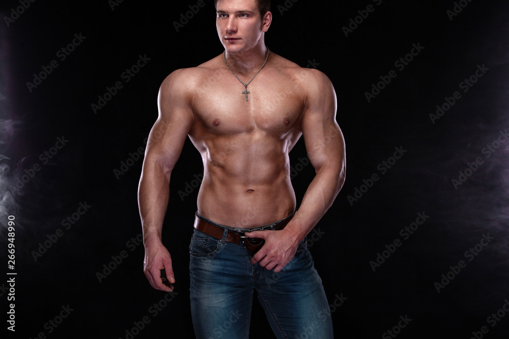 Bodybuilding competitions on the scene. Man sportsmen physique and athlete. Black background with lights.