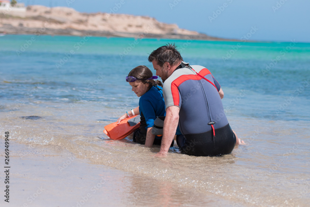 Obraz premium Happy child playing on the beach with dad