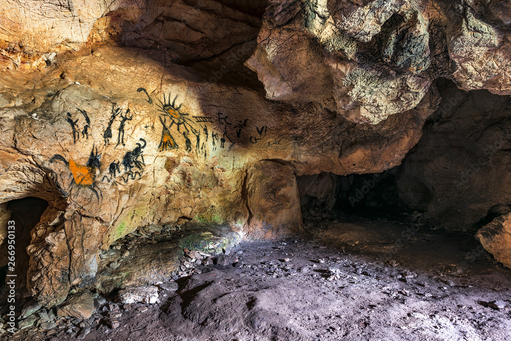Obraz premium Drawing of an ancient Stone Age man in a cave. Prehistoric painting. 