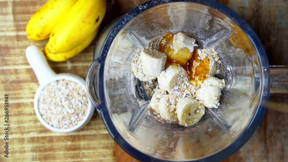 Honey pouring in a blender with ripe banana and Rolled oats, super slow motion video. Honey pouring in a blender with ripe banana and Rolled oats, super slow motion video.