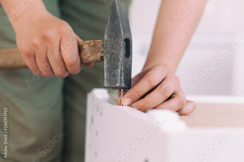Woman carpenter hitting nail with hammer