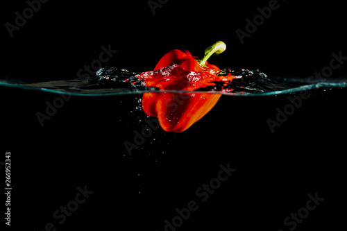 Bild auf Leinwand Red bell pepper under water on black background.