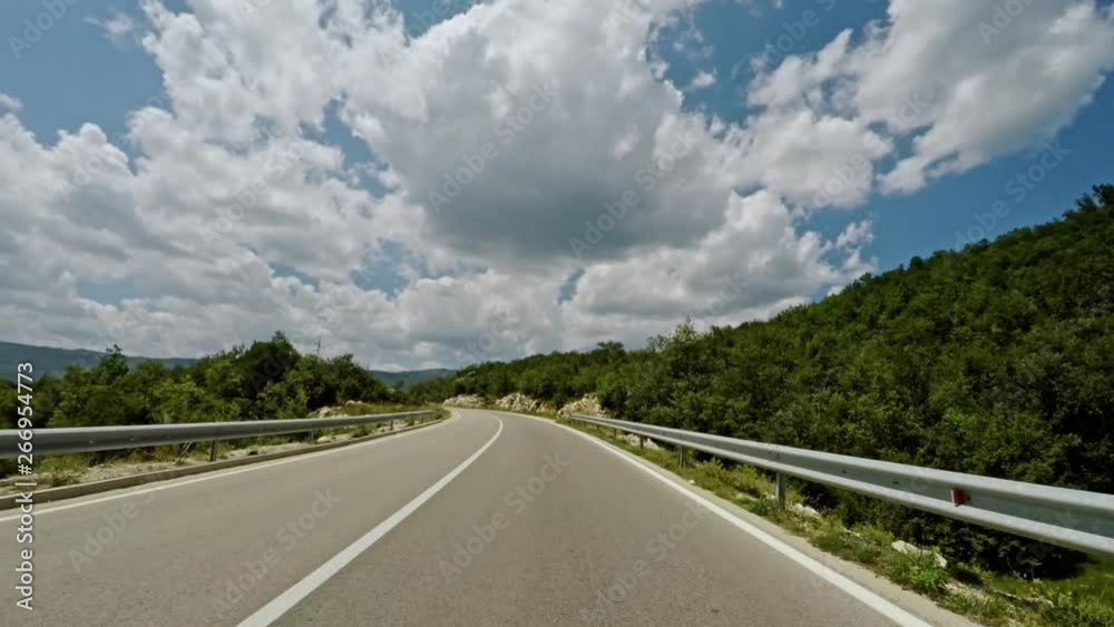 Driving along a motorway in forested mountains Driving along a motorway in forested mountains