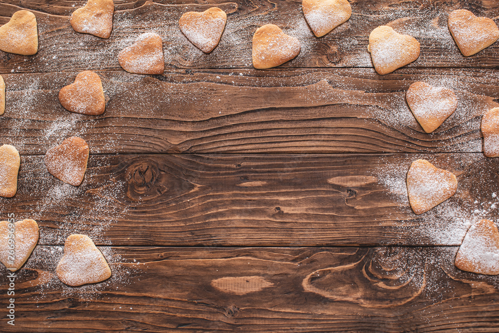 cookies heart shape sprinkled with powdered sugar on a wooden background. copy space cookies heart shape sprinkled with powdered sugar on a wooden background. copy space