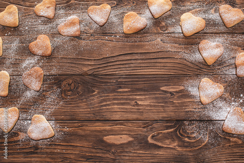cookies heart shape sprinkled with powdered sugar on a wooden background. copy space