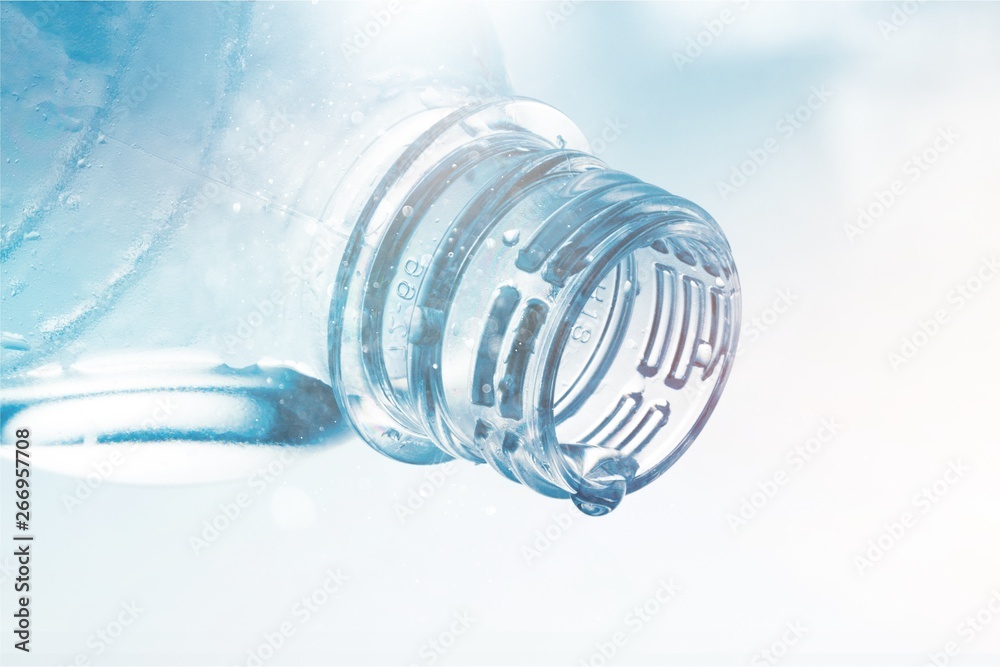 Water Drop Pouring out of Plastic Bottle on the Blue Background Water Drop Pouring out of Plastic Bottle on the Blue Background