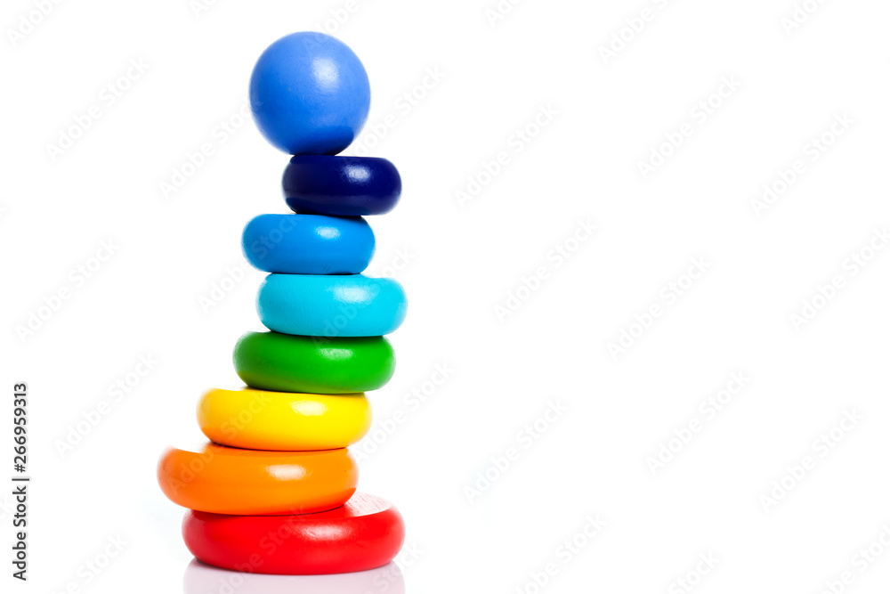 child pyramid of round shape from wooden parts of different colors isolated on white background with place for text. Copy Space multi colorful toy. child pyramid of round shape from wooden parts of different colors isolated on white background with place for text. Copy Space multi colorful toy.